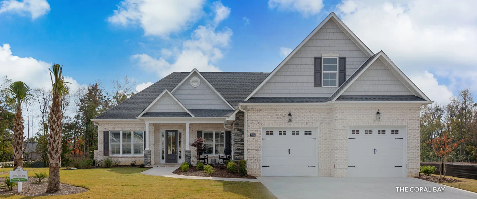 gallery-exteriors (19) Modern single-story brick house with gray roof, manicured lawn, and palm trees, showcasing the work of a skilled home builder.