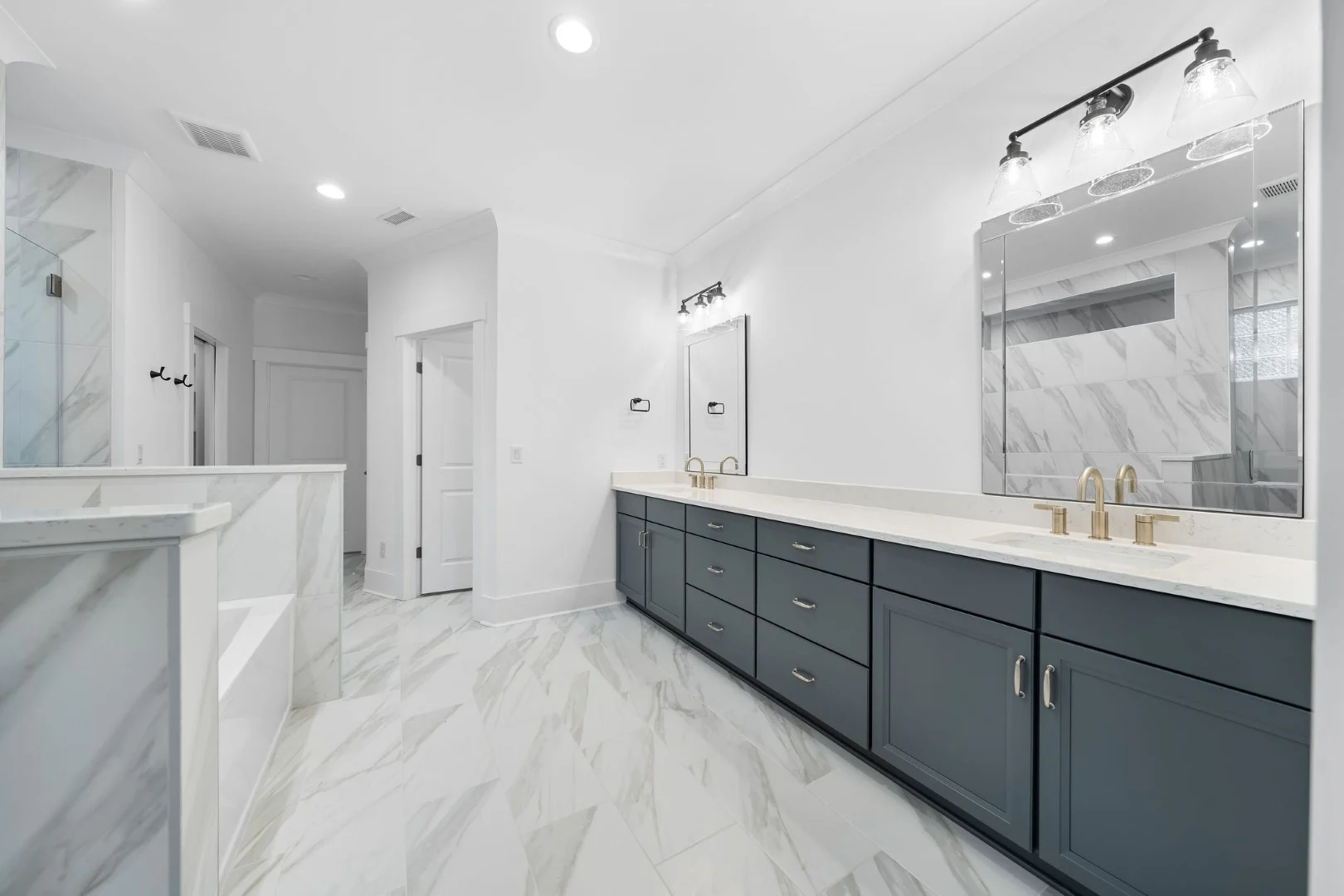 gallery-kitchen (20) Modern bathroom with gray vanity, marble floor, and sleek fixtures. Spacious and well-lit, showcasing home builder's craftsmanship.