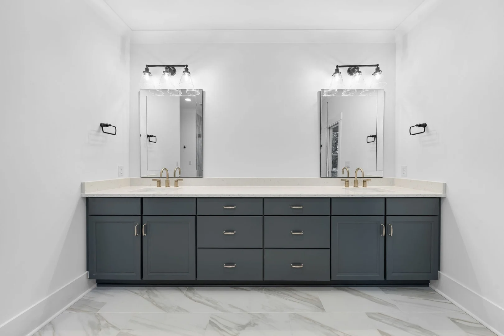 gallery-kitchen (21) Modern bathroom features dark gray double vanity with dual mirrors, sleek faucets, and bright overhead lighting, showcasing home builder craftsmanship