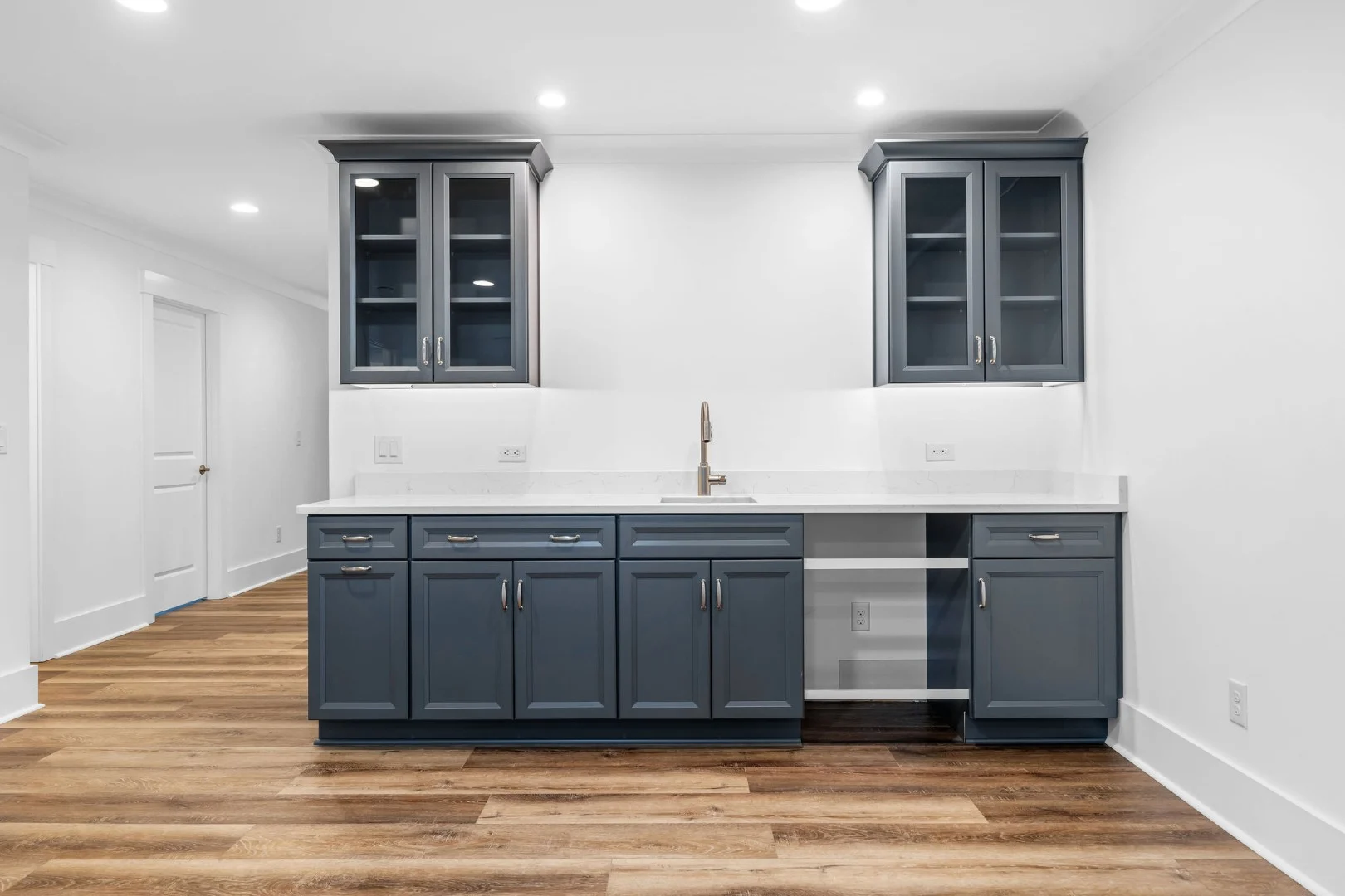 gallery-kitchen (24) Spacious kitchen with sleek gray cabinets, white countertops, and modern sink, ideal for innovative home builder designs.