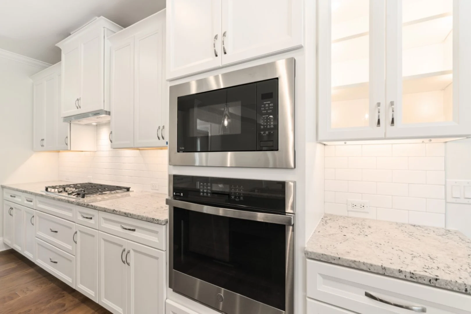 gallery-kitchen (37) Modern kitchen with white cabinets, stainless steel appliances, granite countertops, and subway tile backsplash, designed by home builder.
