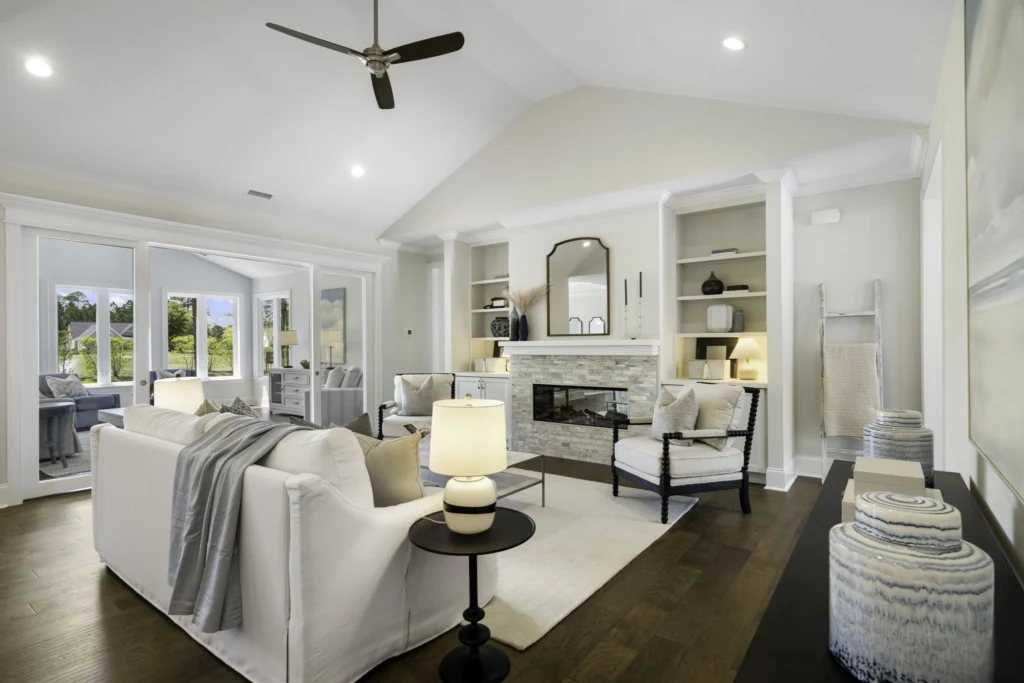 Modern living room with vaulted ceiling, cozy fireplace, and elegant decor. Designed by a home builder for comfort and style.